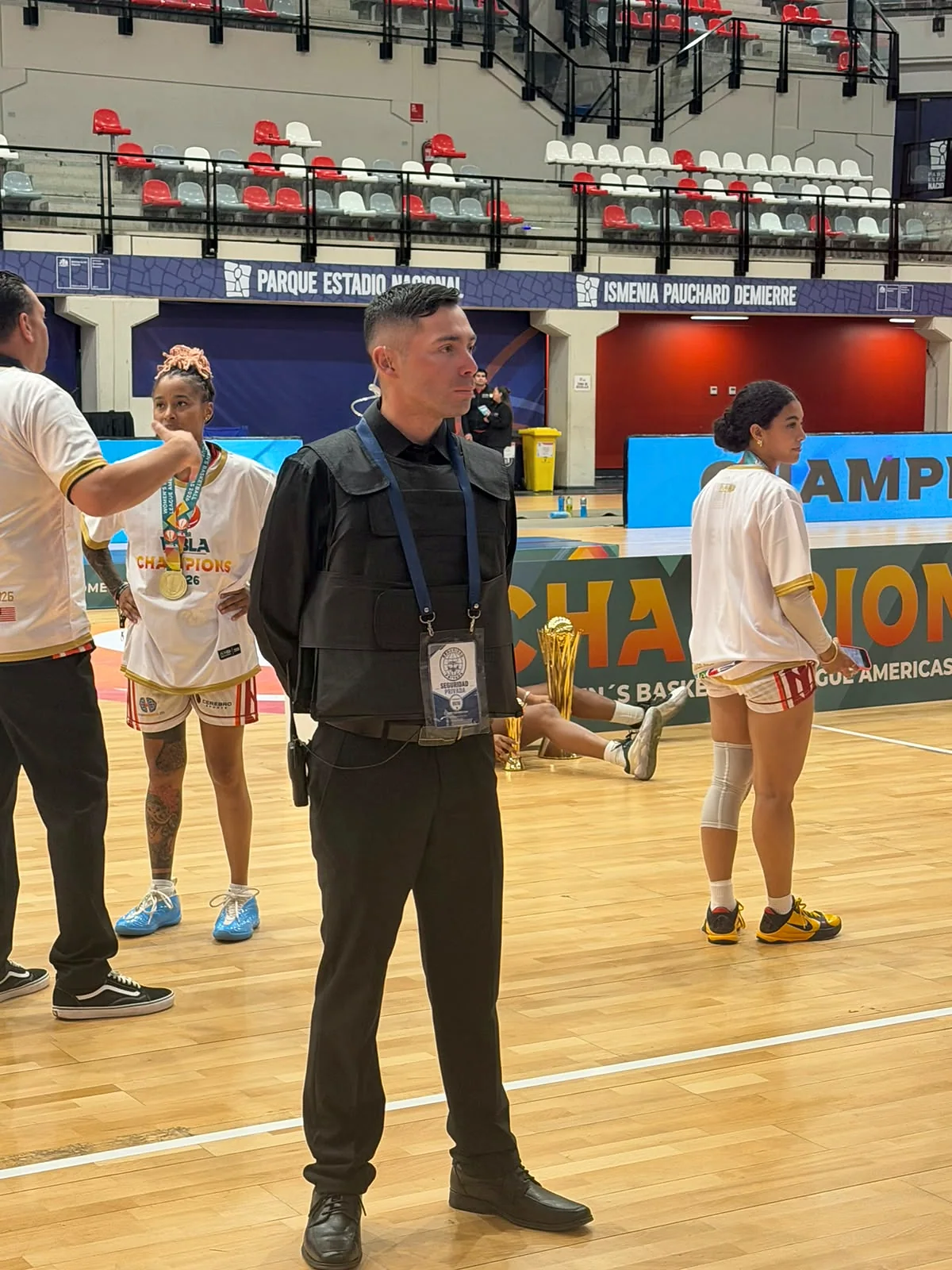 Guardia de seguridad con credencial sobre una cancha de básquetbol