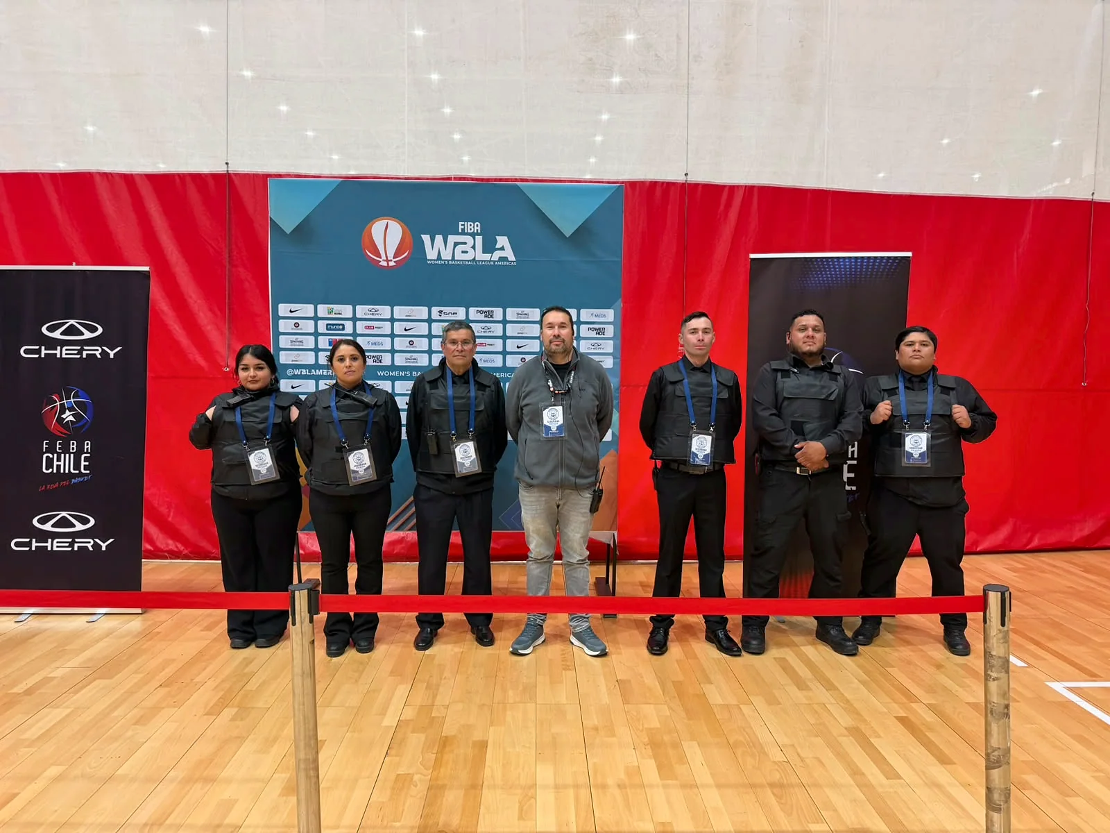 Grupo de personal de seguridad acreditado ante panel de un torneo internacional de básquetbol